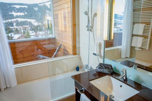 a bathroom with a tub and a sink and a shower at ROBINSON Fieberbrunn - Adults only in Fieberbrunn