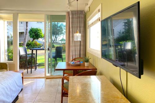a living room with a flat screen tv and a table at Islander on the Beach 164 in Kapaa