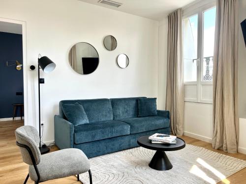 Una sala de estar con un sofá azul y una mesa. en Pick A Flat's Apartment in Grands-Boulevards - Boulevard Saint-Denis, en París