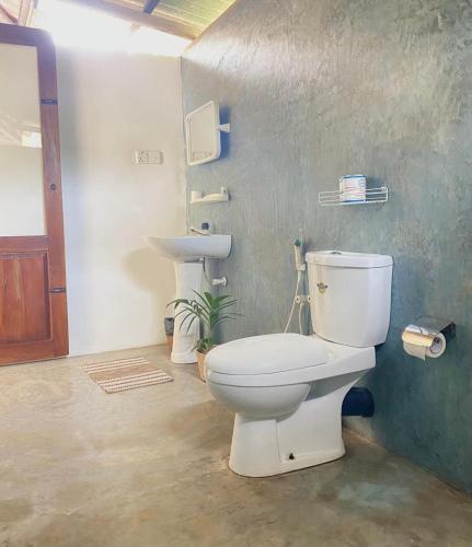 a bathroom with a white toilet and a sink at Sea Sand Resort in Kalpitiya
