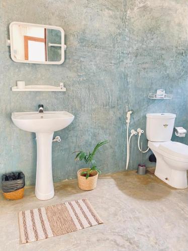 a bathroom with a sink and a toilet at Sea Sand Resort in Kalpitiya