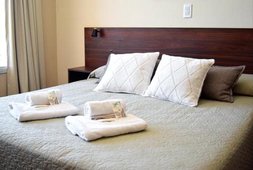 a bedroom with a bed with towels on it at Alamo Hotel in Villa Carlos Paz