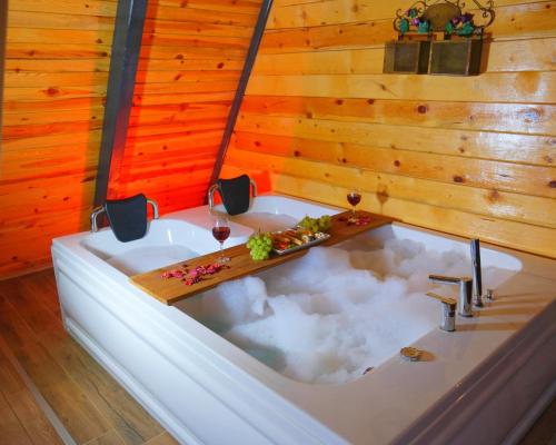 a bathroom with a bath tub with wine glasses at AYBELYA TATİL KÖYÜ in Bafra