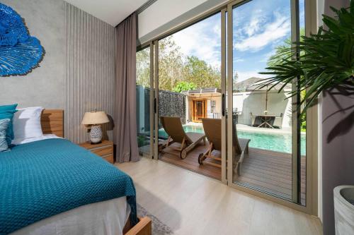 a bedroom with a bed and a balcony with a pool at Wilawan villas in Phuket Town