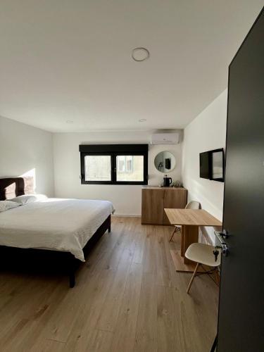 a bedroom with a bed and a desk and a table at Sha Sho in Mostar