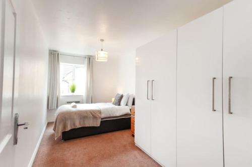a white bedroom with a bed and a window at Snowberry Close - Contractors Long Stay by ShortStayUK in Bristol