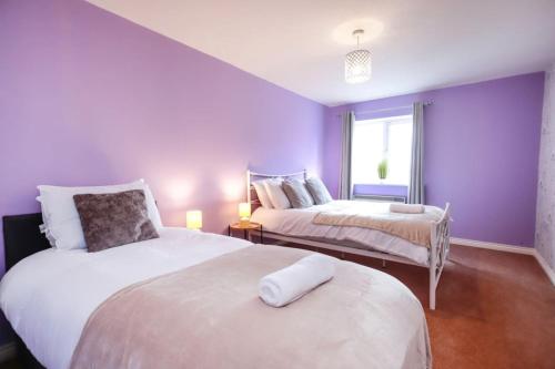 a purple bedroom with two beds and a window at Snowberry Close - Contractors Long Stay by ShortStayUK in Bristol
