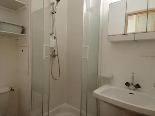 une salle de bain blanche avec une douche et un lavabo dans l'établissement Studio fonctionnel près des pistes avec kitchenette et parking - FR-1-181-2548, à Aime La Plagne