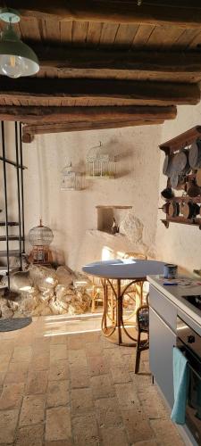 a kitchen with a table and a stove in a room at La casa nella roccia Colline umbre in Battiferro