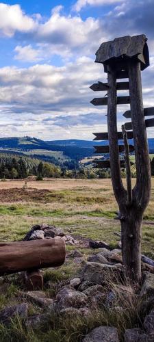 a wooden sign on top of a field at Restaurace a penzion Vlčí jáma in Horní Blatná
