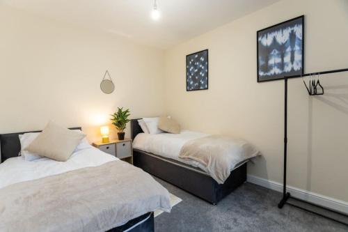 sypialnia z dwoma łóżkami i telewizorem na ścianie w obiekcie Deacon Street-3 Bedroom, Sleeps 7, Long Stay Disc, Parking w mieście Swindon