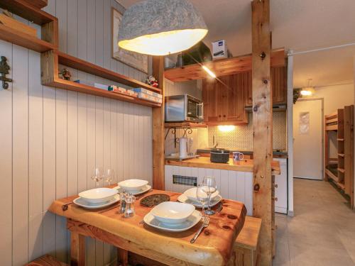 - une cuisine avec une table en bois et de la vaisselle dans l'établissement Studio coquet skis aux pieds avec Wifi et lave-linge - FR-1-694-81, à Val dʼIsère
