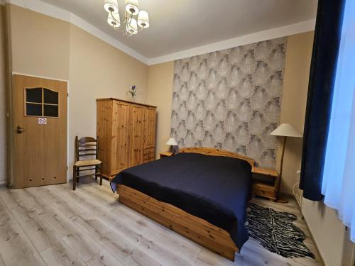 a bedroom with a bed and a chair in it at Willa Wiselka in Wisełka
