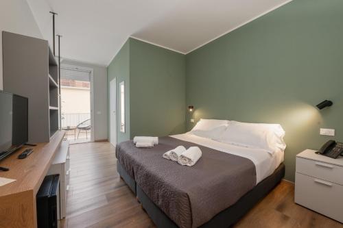 a bedroom with a large bed with towels on it at Hotel Perla in Castiglione della Pescaia