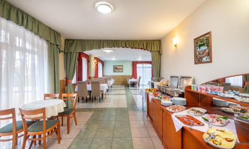 restauracja ze stołami i krzesłami oraz bufetem w obiekcie Platan Hotel w Debreczynie