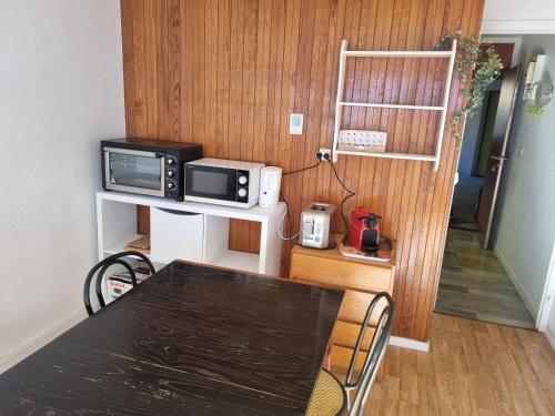 une salle à manger avec une table et un four micro-ondes dans l'établissement Appartement pied des pistes - Résidence La Mongie - Tourmalet, à La Mongie