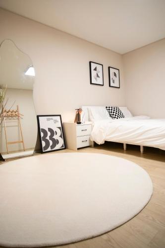 a bedroom with two beds and a white rug at Gyeongju Record Stay Near tourist attractions in Gyeongju