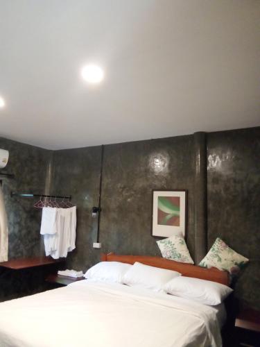 a bedroom with a large white bed with a wall at Hubkhao Resort in Ko Lanta