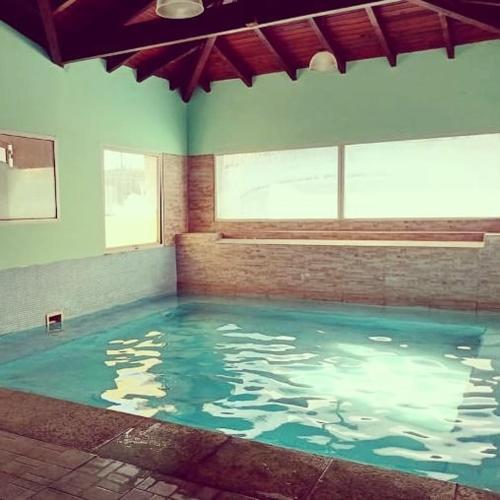 a swimming pool with blue water in a room at Posada Spa Anabela in Huerta Grande