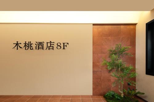 a sign on a wall next to a door at 木桃酒店Mutao Hotel in Hangzhou