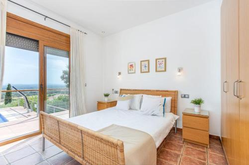 a bedroom with a large bed and a balcony at V024 - Villa Colina in Palau-Saverdera