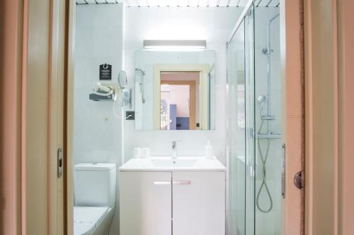 a white bathroom with a sink and a shower at Alda Don Carlos in Santander