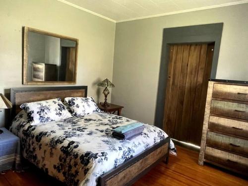 a bedroom with a bed with a dresser and a mirror at The Tipsy Gypsy in Hunter