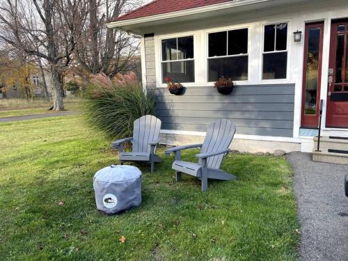 two chairs sitting in the grass in front of a house at The Tipsy Gypsy in Hunter
