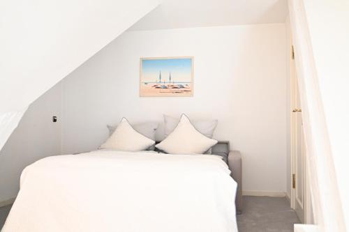 a bedroom with a white bed with white pillows at Landsitzhotel und Seminarium Peterhof in Hodorf