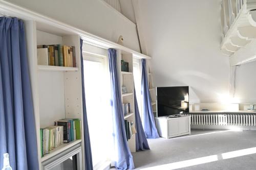 a room with a window with blue curtains and a tv at Landsitzhotel und Seminarium Peterhof in Hodorf