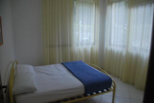 a small bed in a room with a window at Rosolina cozy flat wth pool in Rosolina Mare