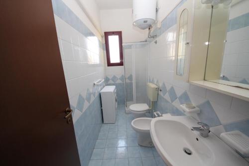 a bathroom with two toilets and a sink and a mirror at Rosolina cozy flat wth pool in Rosolina Mare