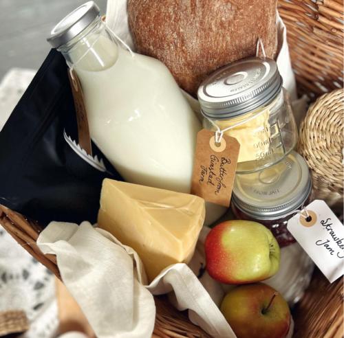 een mand met eten, kaas, appels en melk bij Vesterålen Apartment in Bø i Vesterålen