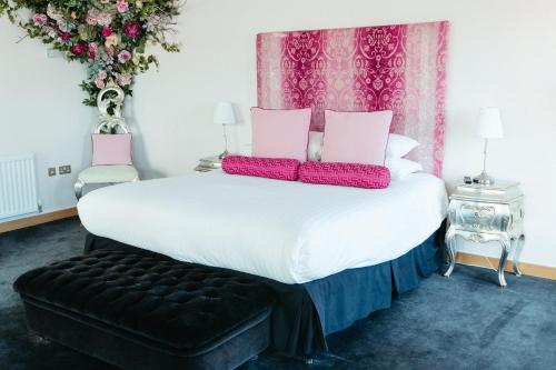a bedroom with a large white bed with pink pillows at Posh Pads - Liverpool 1 - Apart-Hotel in Liverpool