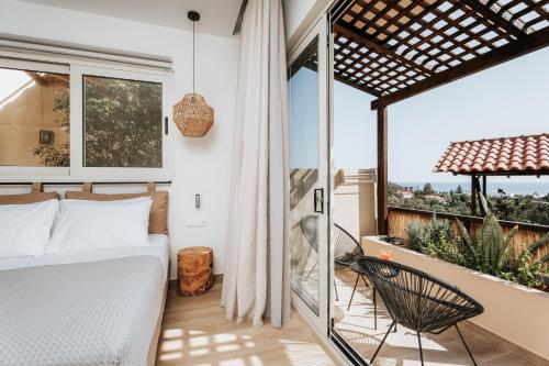 a bedroom with a bed and a balcony at Paralos The Maxine Adults Only in Agia Galini