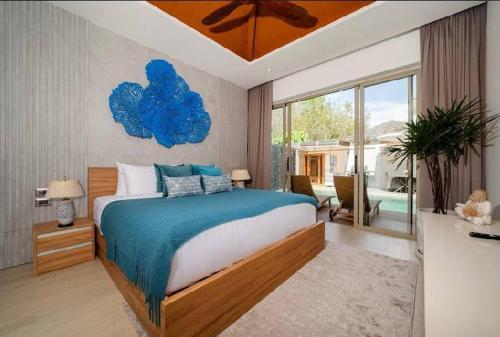 a bedroom with a large bed and a large window at Wilawan villas in Phuket Town