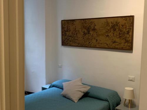 a room with a blue bed and a painting on the wall at Cernaia by Farris & Cors in Genova