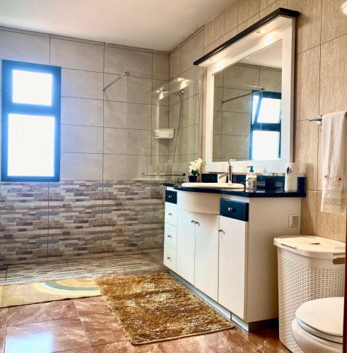 a bathroom with a sink and a mirror and a toilet at Casa Gomes in Calheta
