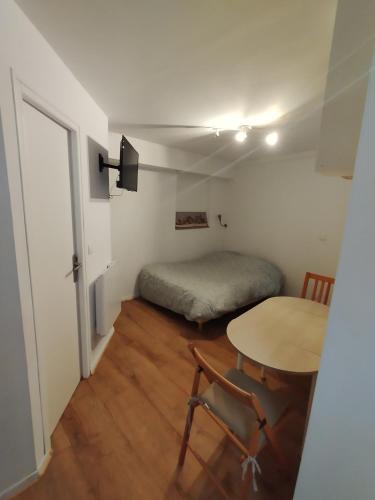 Cette petite chambre comprend une table et un lit. dans l'établissement Studio Porteille d'Ax entièrement rénové !, à Ax-les-Thermes