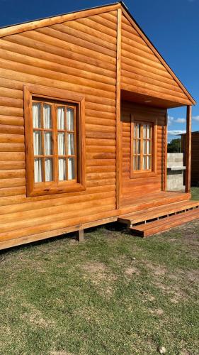 a log cabin with two windows on the side of it at La Vita CdelU in Concepción del Uruguay
