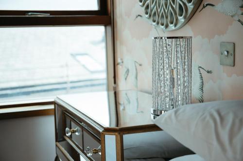 a bedroom with a bed and a dresser and a window at Posh Pads - Liverpool 1 - Apart-Hotel in Liverpool