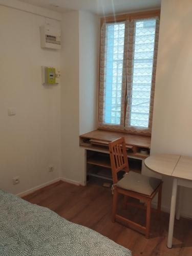 - une chambre avec un bureau, une chaise et une fenêtre dans l'établissement Studio Porteille d'Ax entièrement rénové !, à Ax-les-Thermes