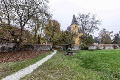 an old building with a tower in a yard at Apartments am Schloss Mühldorf in Feldkirchen an der Donau