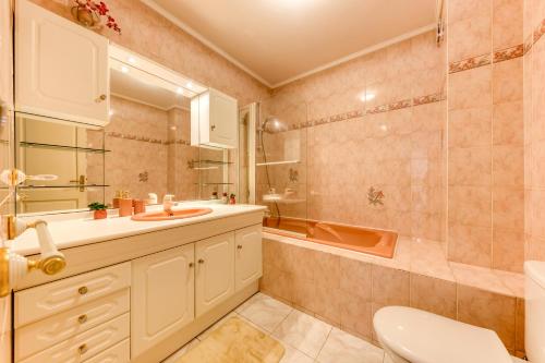 une salle de bain avec un lavabo, une baignoire et des toilettes dans l'établissement Maison Évasion Panoramique entre Paris et Disney, à Noisy-le-Sec