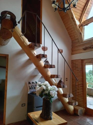 a staircase in a house with a vase of flowers on a table at Finca Chuchiyá cabañas Tecpan in Tecpán Guatemala