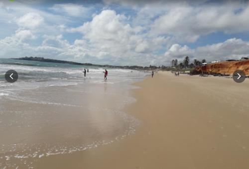 a group of people walking on a beach at Corais de Cotovelo in Parnamirim