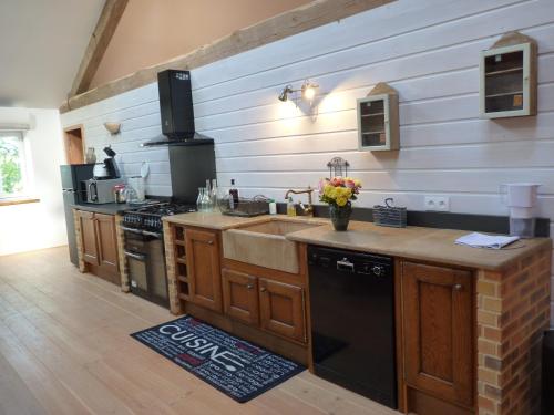une cuisine avec un évier et une cuisinière dans l'établissement Gîte Du Verger Saint Vincent, à Beaujeu