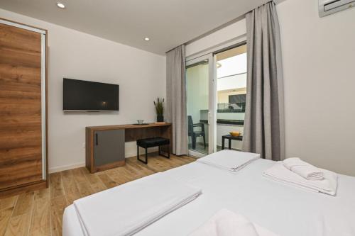 a hotel room with a bed and a television at Boutique Hotel IVY'Z in Novalja