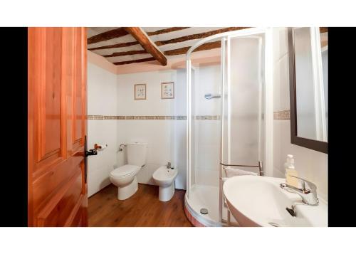 Un baño con inodoro, lavabo y bañera. en Casa Llano, en Llano de Bureba