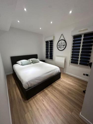 une chambre avec un lit et une horloge au mur dans l'établissement F2 centre-ville Netflix, Disney plus, à Amiens